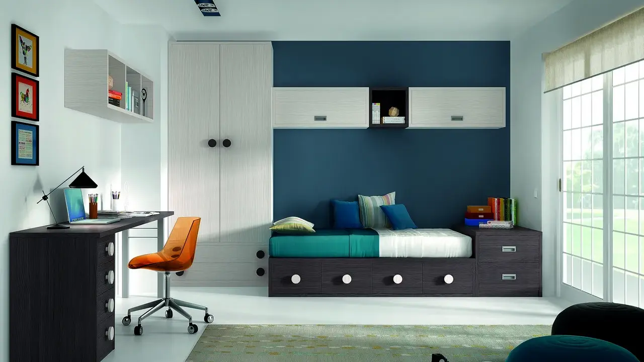 Habitación juvenil con pared azul y blanca, cama con cajones, escritorio y armario. Ideal para pintar habitación juvenil dos colores.
