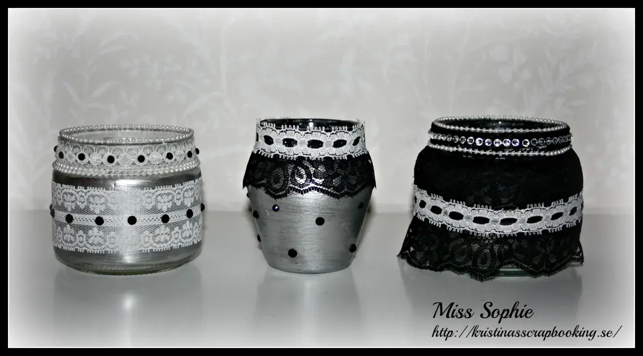 Three decorated glass jars with lace and beads.