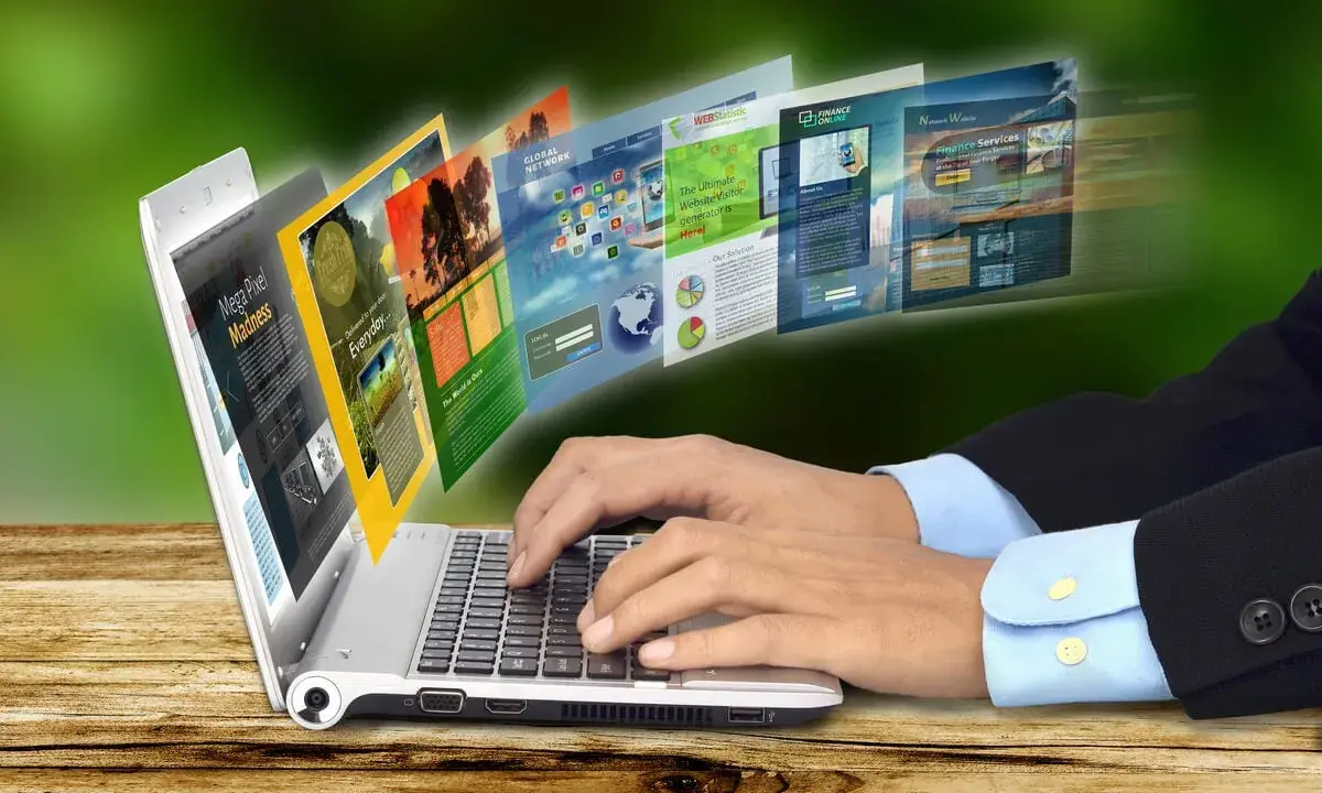 Dłonie piszą na laptopie, z którego wychodzą strony internetowe. To przykład, jak retoryka co to, czyli sztuka perswazji, działa w sieci.