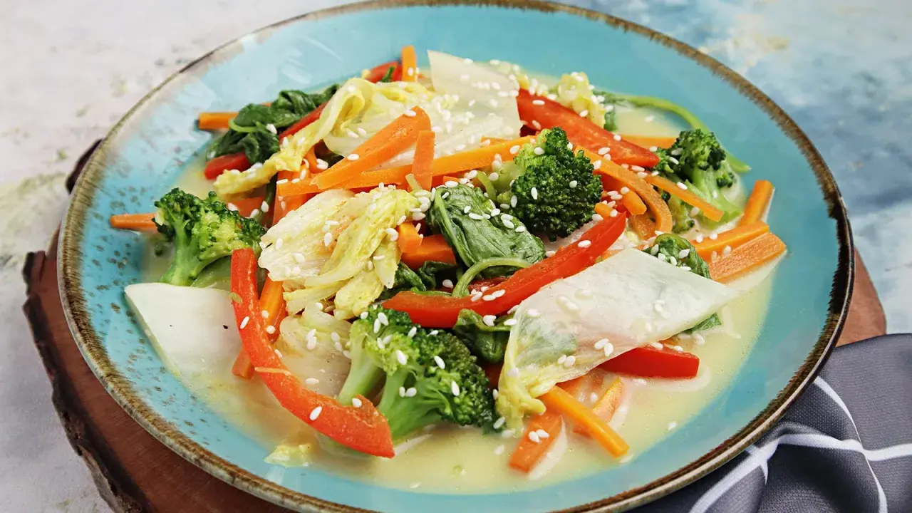 Buntes Gemüsegericht mit Chinakohl, Karotten, Brokkoli und Paprika in cremiger Sauce, bestreut mit Sesam. Leckere Chinakohl Rezepte!