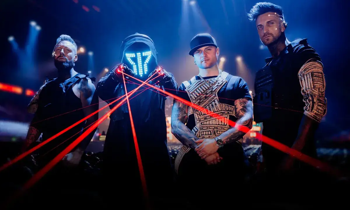 Medlemmar av Smash Into Pieces poserar med röda laserstrålar framför en mörk bakgrund med blå ljus.