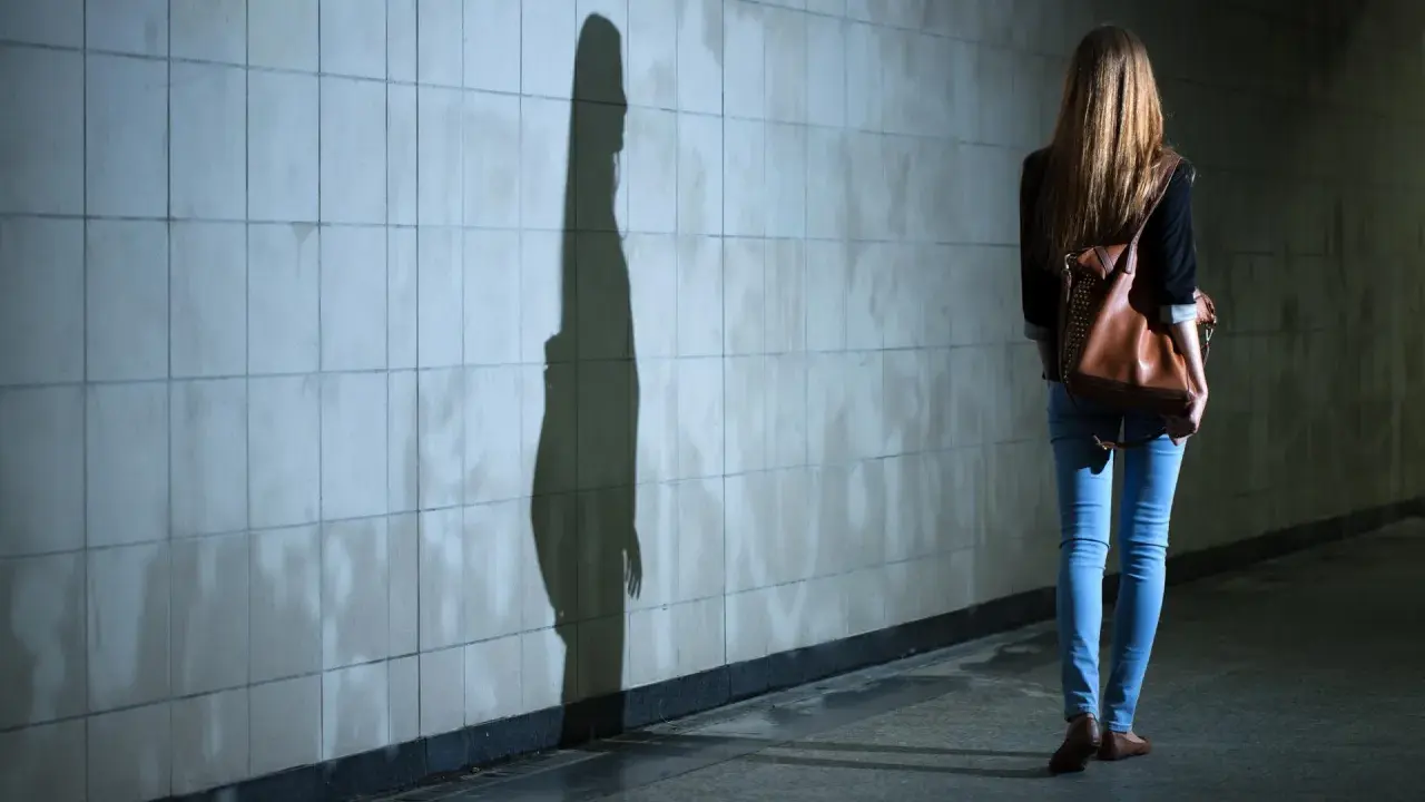 Dziewczyna z plecakiem idzie przez tunel, jej cień na ścianie symbolizuje dyfuzję odpowiedzialności.
