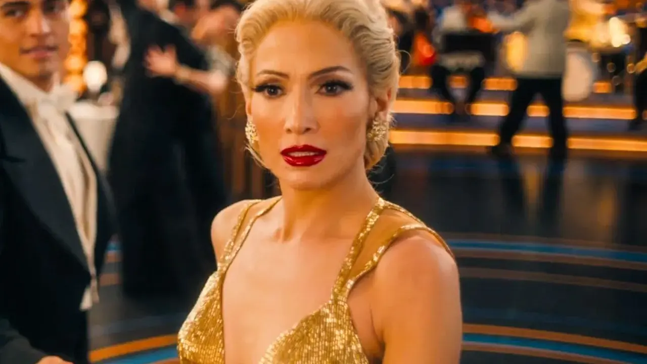 Jennifer Lopez i en glittrande guldig klänning på en dansgolv, en scen från filmer med Jennifer Lopez.
