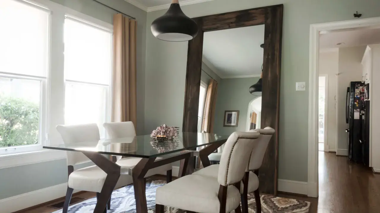 Un grand miroir rustique reflète la salle à manger, offrant une idée de où mettre un miroir dans une salle à manger pour agrandir l'espace.