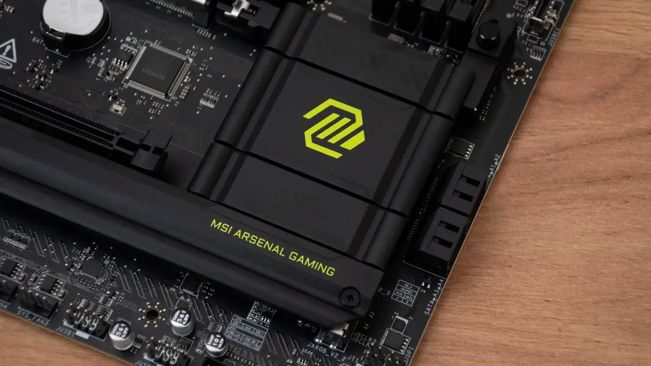 Płyta główna MSI z logo "MSI ARSENAL GAMING". Widoczny radiator z zielonym symbolem, a pod nim znajduje się chipset.