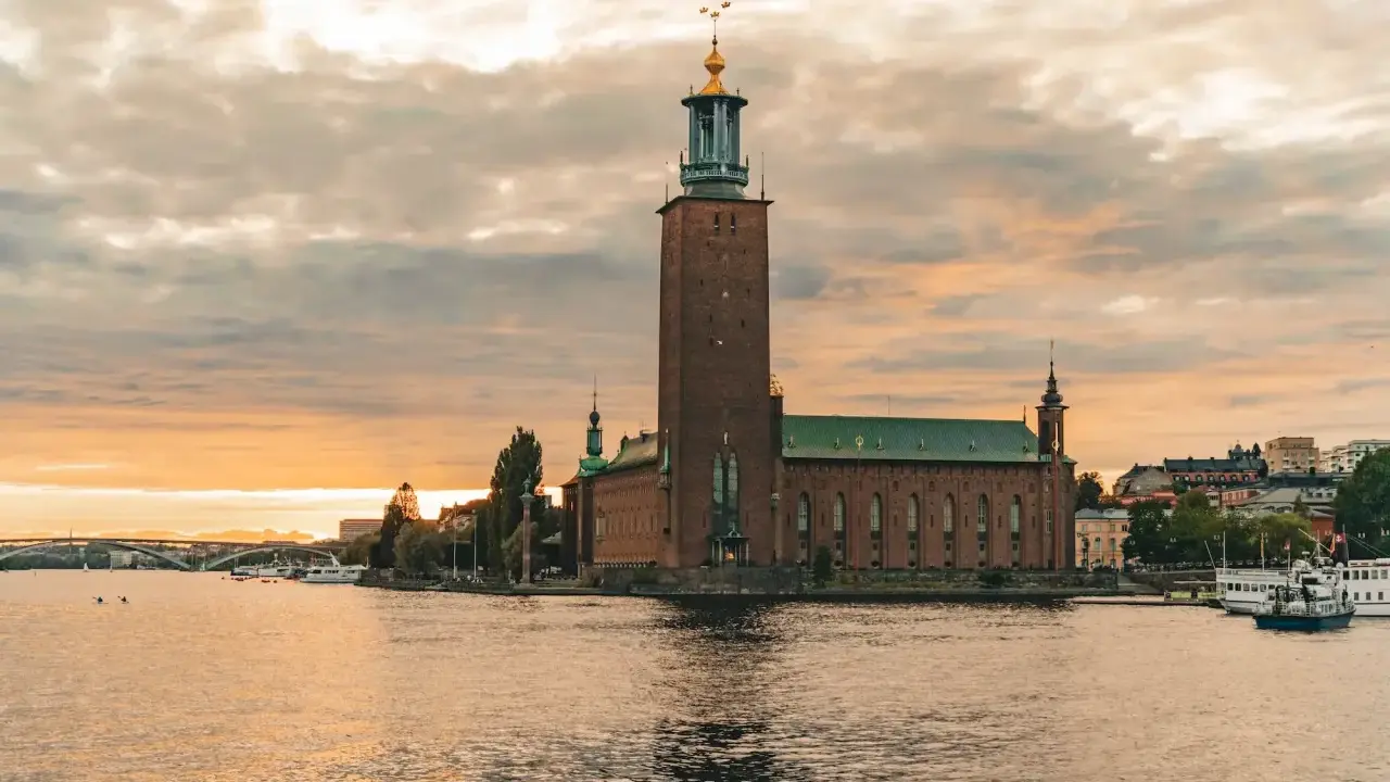 Stadshuset i Stockholm vid solnedgången. En vacker vy som inspirerar till roliga saker att göra i Stockholm, som en båttur eller promenad längs vattnet.