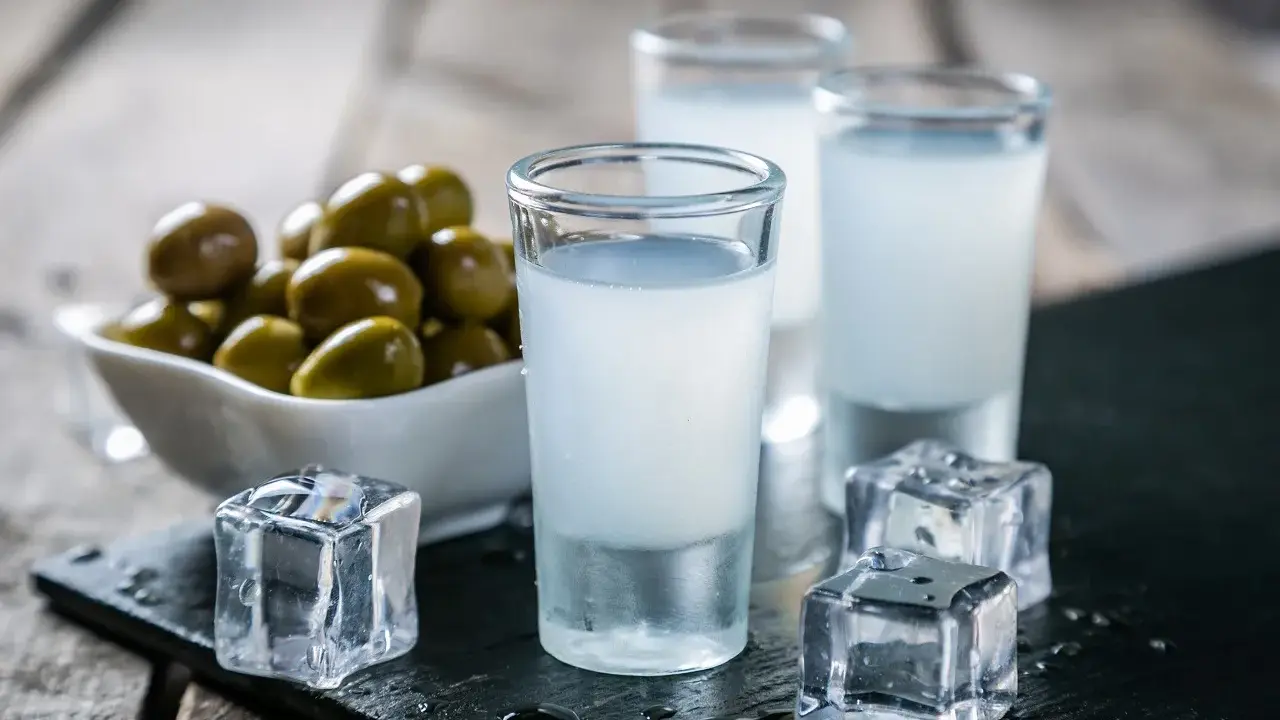 Trzy kieliszki z mlecznym ouzo, kostki lodu i miseczka oliwek. Tak pije się ouzo, by poczuć smak Grecji.