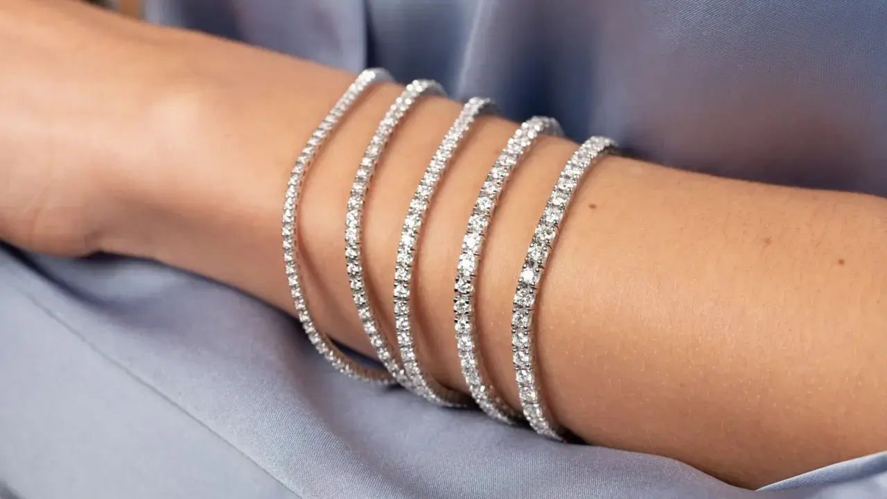 Bracciale tennis, un gioiello scintillante che ricorda la linea di un campo da gioco, indossato su un braccio.