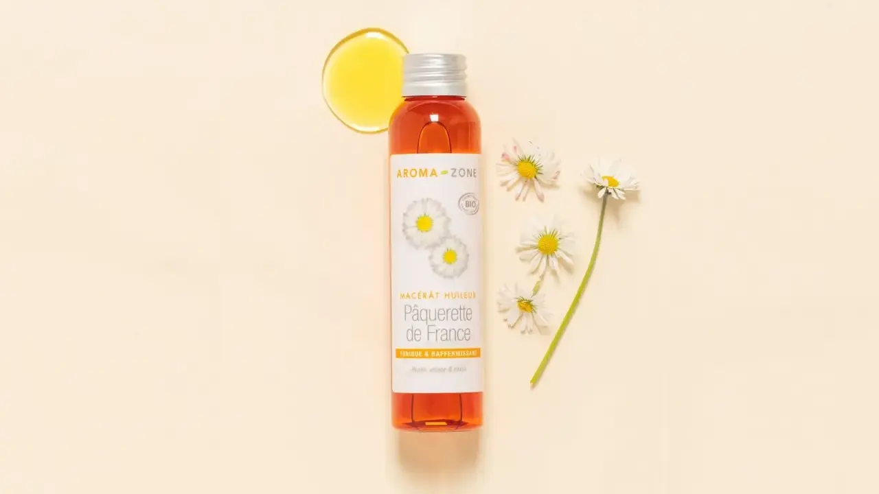 Flacon d'huile de pâquerette Aroma-Zone, avec des pâquerettes. Attention, l'huile de pâquerette danger potentiel pour certaines peaux.
