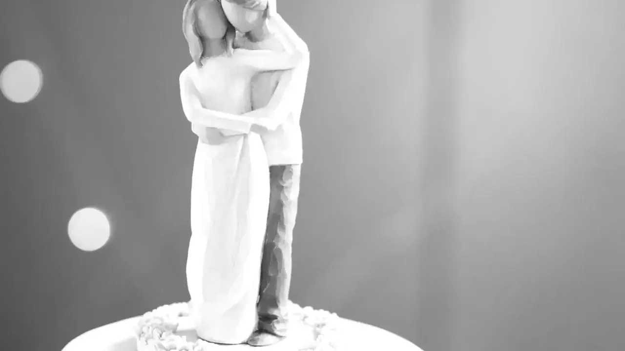 Figura de pareja abrazada, celebrando sus 20 años bodas de. Un símbolo de amor eterno sobre un pastel.