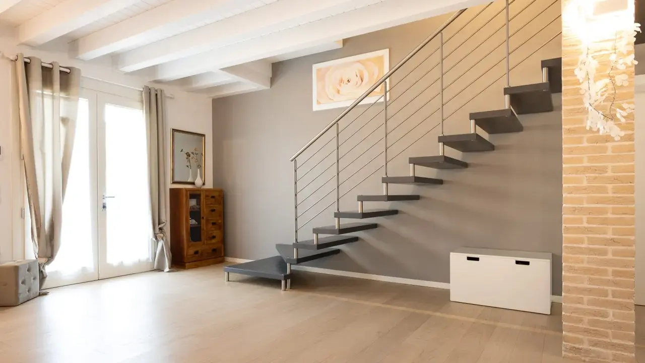 Moderna scala a sbalzo, con gradini scuri e corrimano in metallo. Soluzioni per chi cerca un design audace.