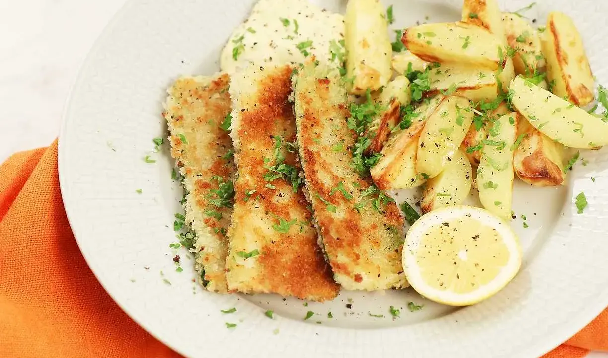 Krispigt friterad zucchini med pommes frites, en klick sås och en citronskiva.