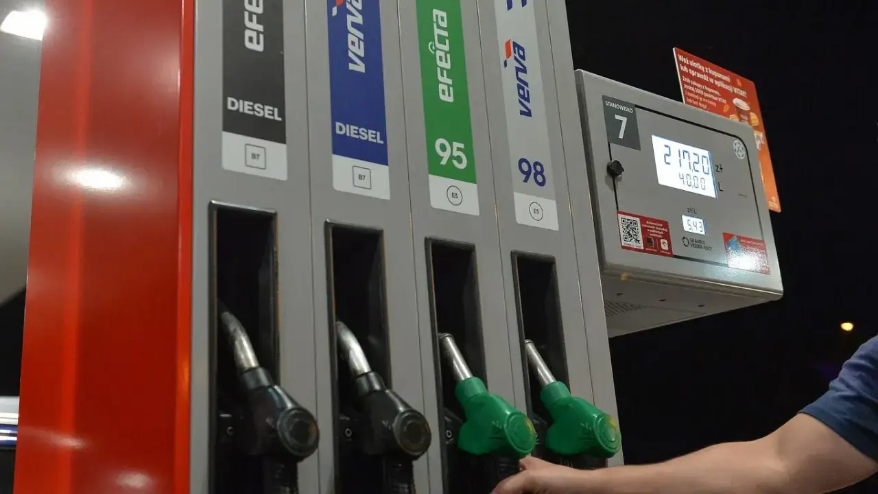 Dłoń sięga po dystrybutor z napisem "verva diesel" na stacji paliw. Obok widnieją inne rodzaje paliwa.
