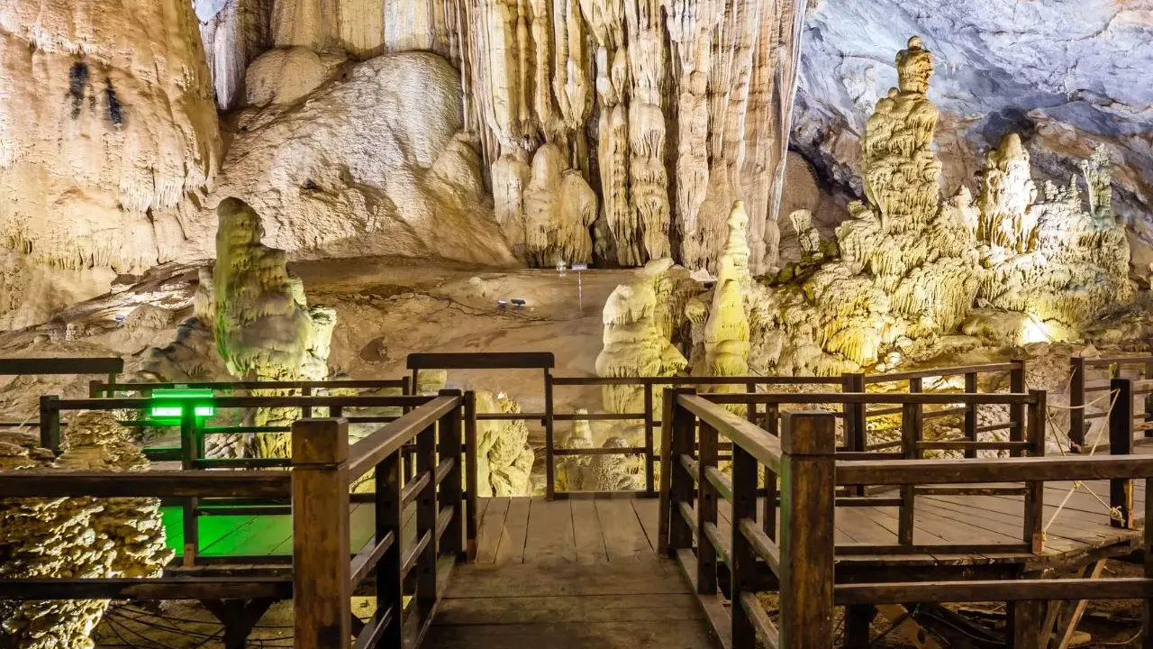 Drewniana kładka prowadzi przez imponujące jaskinie w Polsce, ukazując stalaktyty i stalagmity.