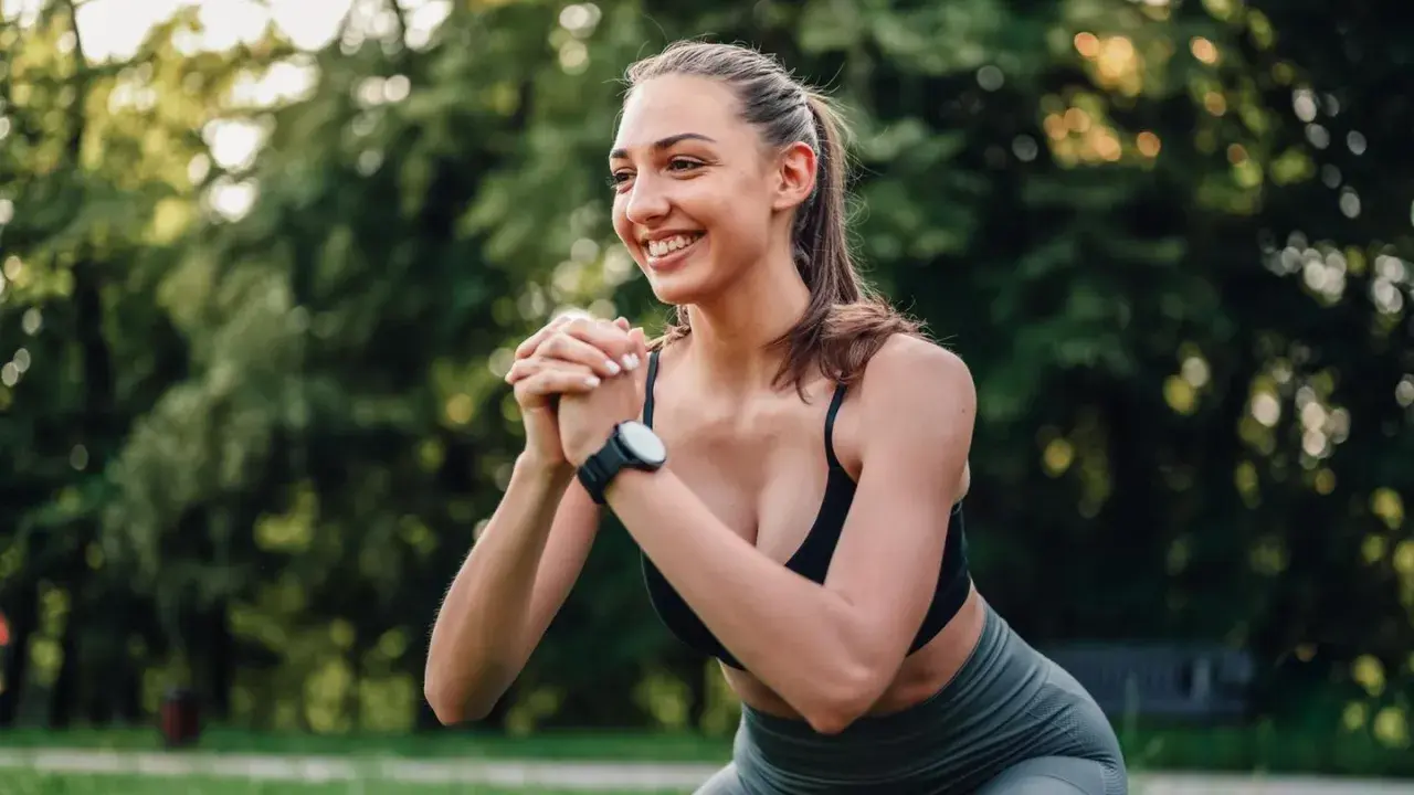 Frau beim Squatten im Freien, strahlt Selbstvertrauen aus. Ein Beispiel für die Ergebnisse von 3 monat krafttraining frauen vorher nachher.