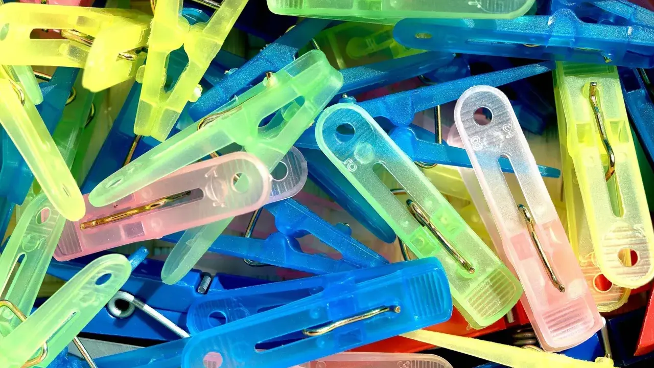 Kolorowe spinacze do prania, idealne do domowych sposobów czyszczenia plastiku.