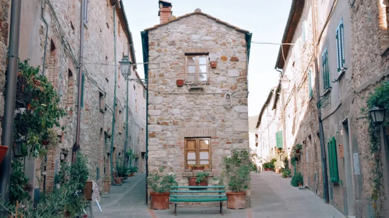 Un vicolo stretto con case in pietra e piante in vaso. Un invito a scoprire cosa vedere a Cecina, tra scorci pittoreschi e storia.