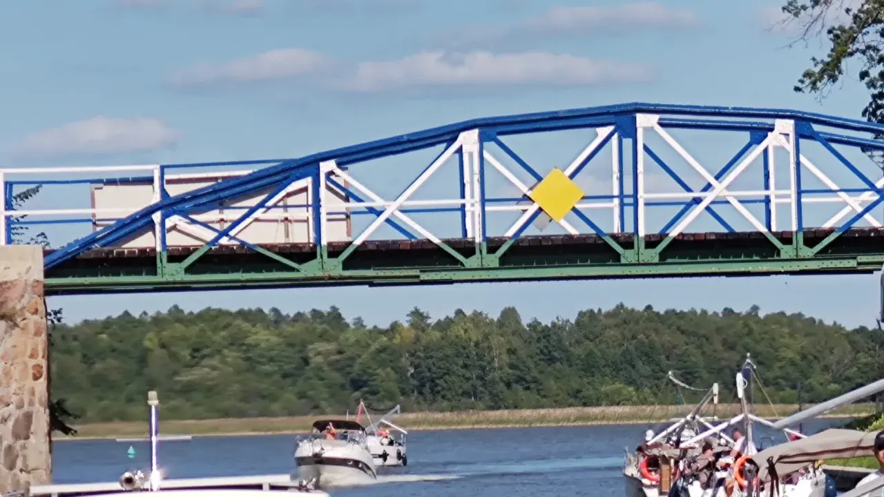 Żółty romb na niebiesko-białym moście to jeden z znaków kardynalnych na wodzie, wskazujący drogę wodną.