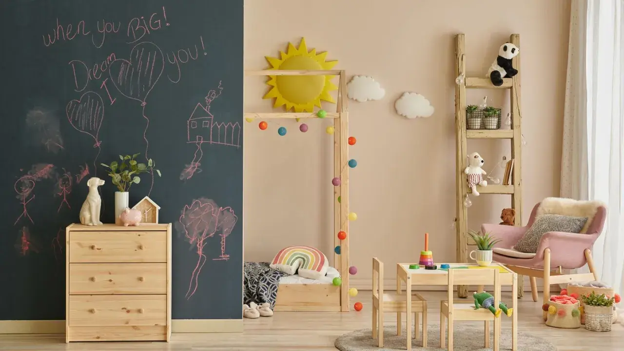 Ein gemütliches Montessori Kinderzimmer für 5-Jährige mit Tafelwand, Holzmöbeln, Spielzeug und einer Leiter als Regal.