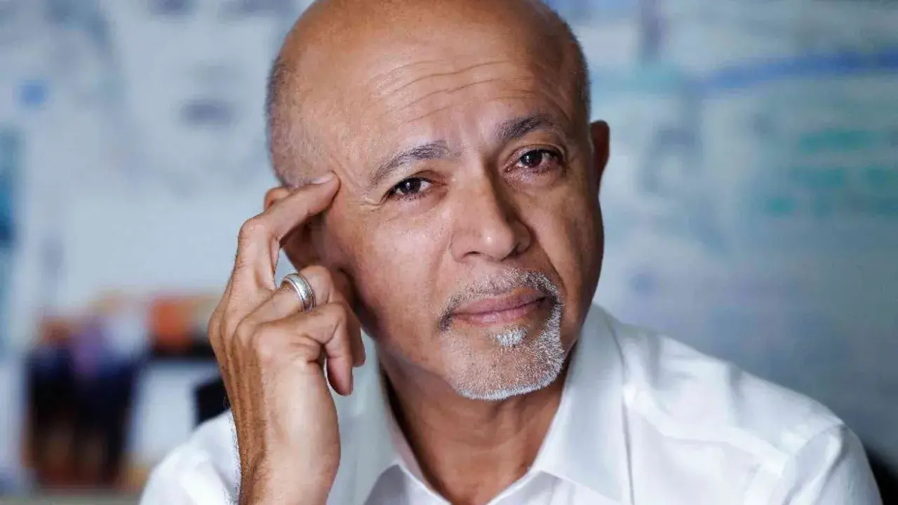 Ritratto di Abraham Verghese, con la mano sulla tempia, pensieroso.