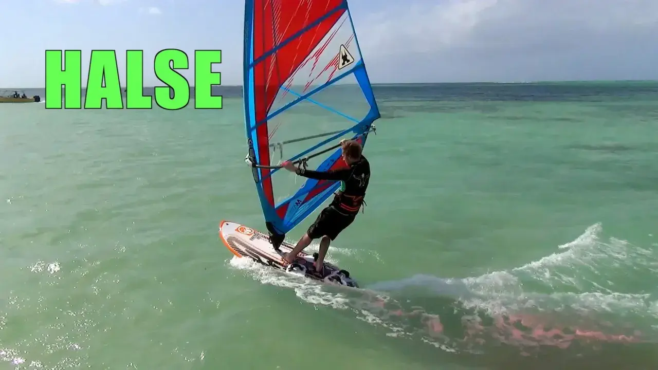 Windsurfer führt eine Halse auf türkisfarbenem Wasser aus, mit dem Wort "HALSE" in grüner Schrift.