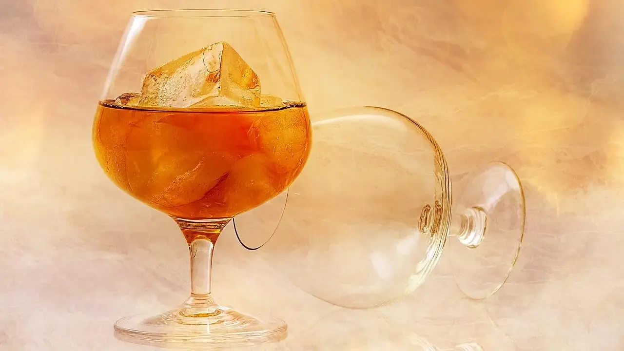 Kieliszek z brandy i lodem, obok pusty, przewrócony kieliszek. Idealny sposób, jak pić brandy.