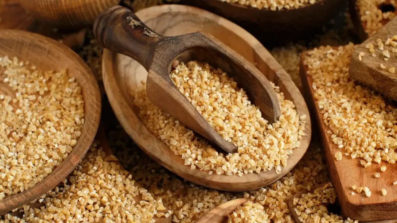 Kasza bulgur w drewnianych misach, gotowa do spożycia. Niski indeks glikemiczny sprawia, że jest zdrowym wyborem.