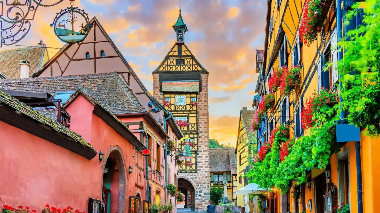 Un pueblo de cuento en Alsacia, con casas coloridas, flores y una torre con reloj. ¡Mucho que ver en Alsacia!
