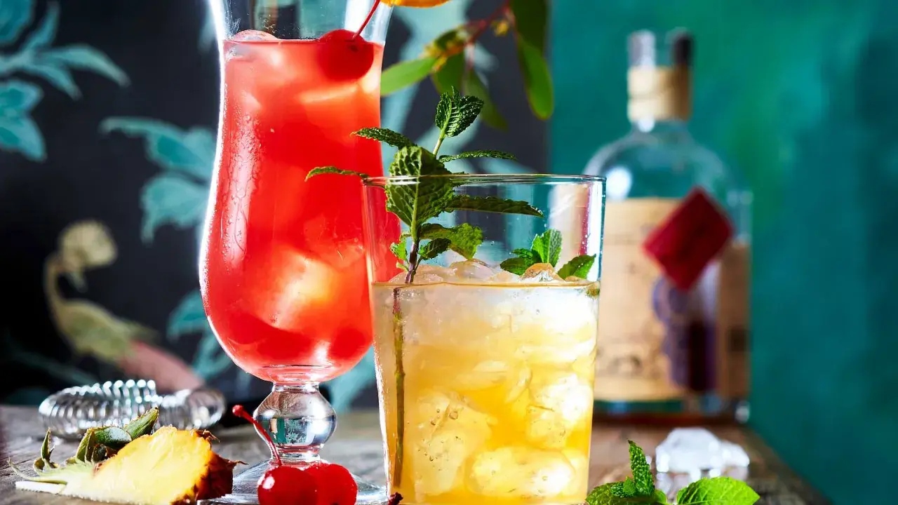 Zwei erfrischende Cocktails, einer rot, der andere gelb, mit Minze und Früchten. Ein **Cocktail mit Bier**-Mix? Vielleicht.