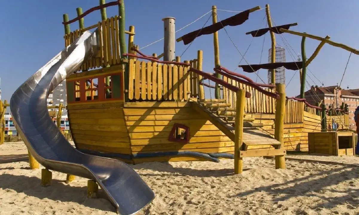 Parque infantil con barco de madera y tobogán, ideal para la vitoria con niños. ¡Aventuras piratas garantizadas!