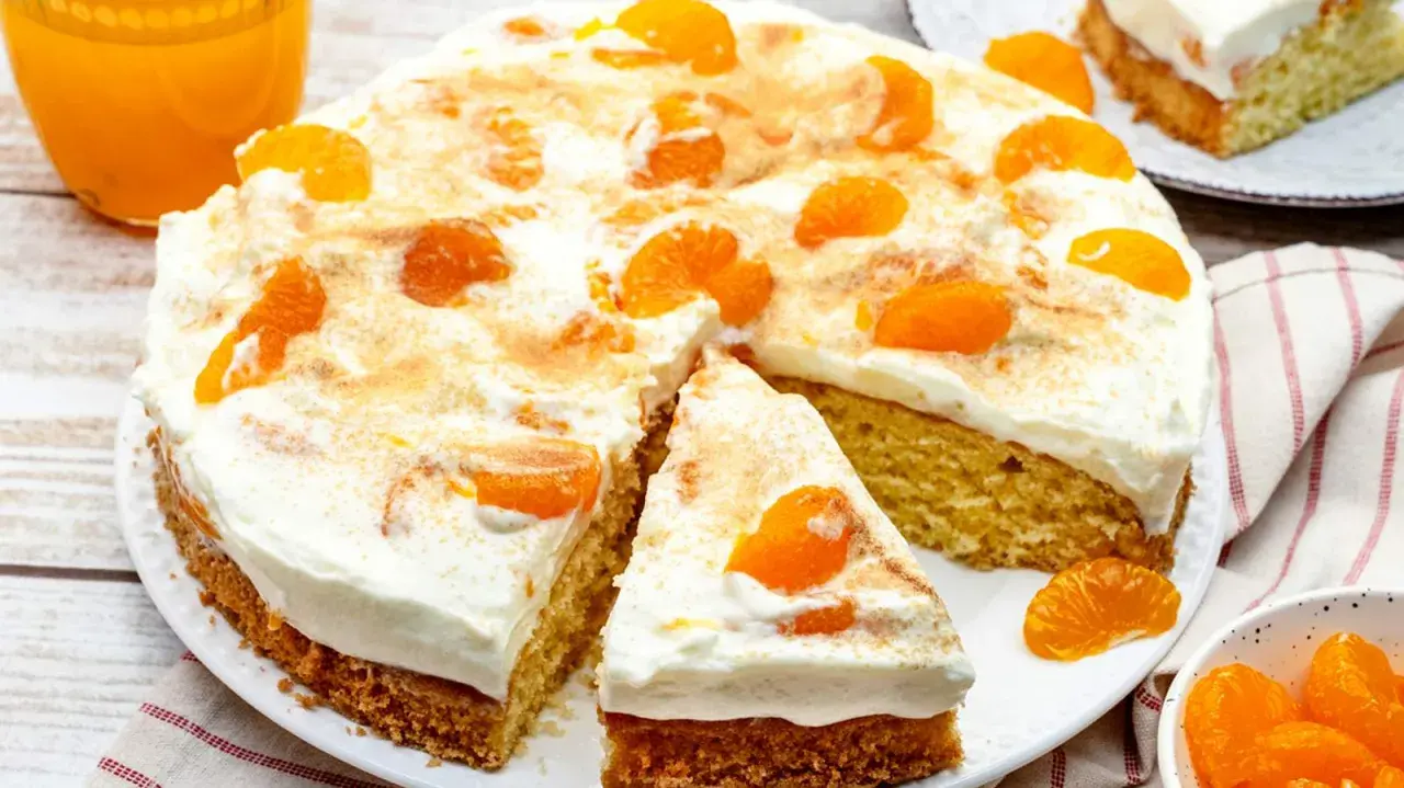 Ein saftiger Fantakuchen, perfekt als Tassenrezept, mit viel Sahne und Mandarinenstücken bestreut.