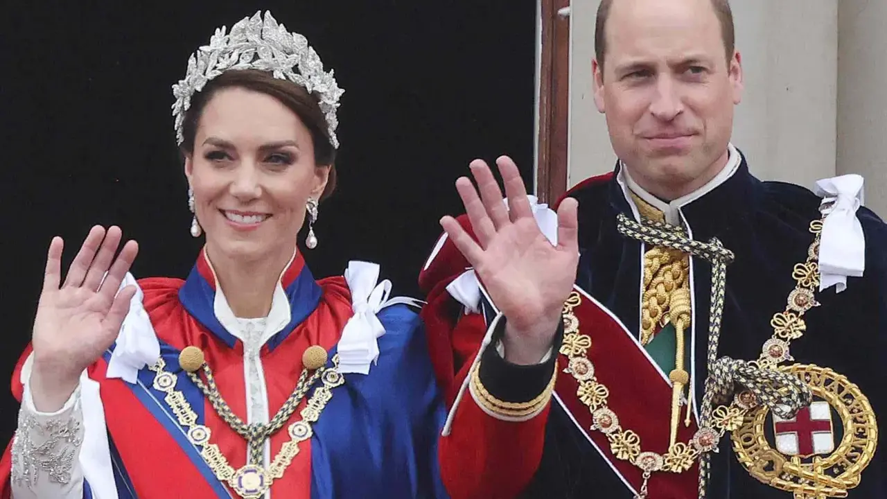 Kate Middleton och Prins William, medlemmar av brittiska kungahuset, vinkar från en balkong i sina högtidliga dräkter och juveler.