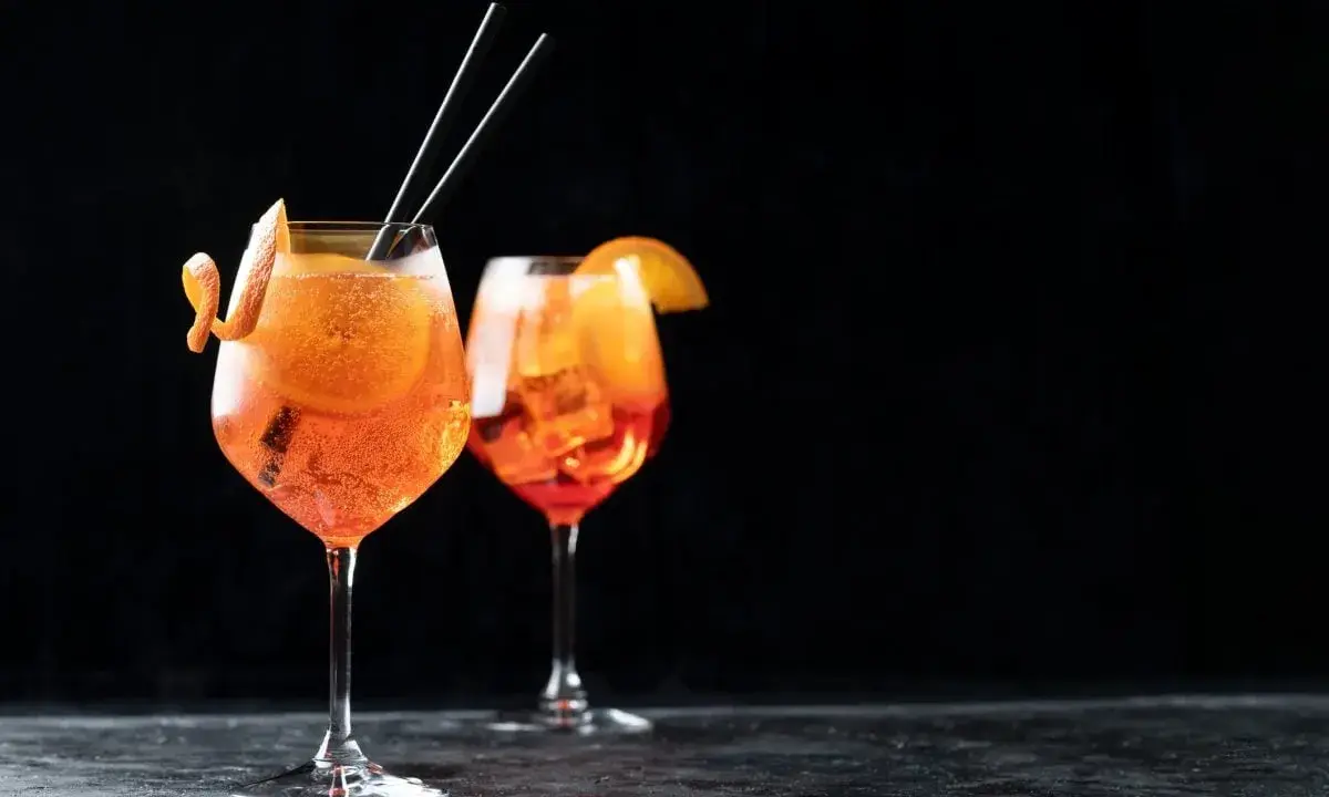 Zwei Aperol Spritz Gläser mit Orangenscheibe und Zitrusschale, perfekt für das Aperol Spritz Rezept in ml.