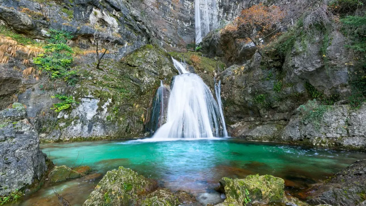Impresionantes cascadas en Albacete, con agua turquesa cayendo por rocas cubiertas de musgo. Un paisaje natural de ensueño.
