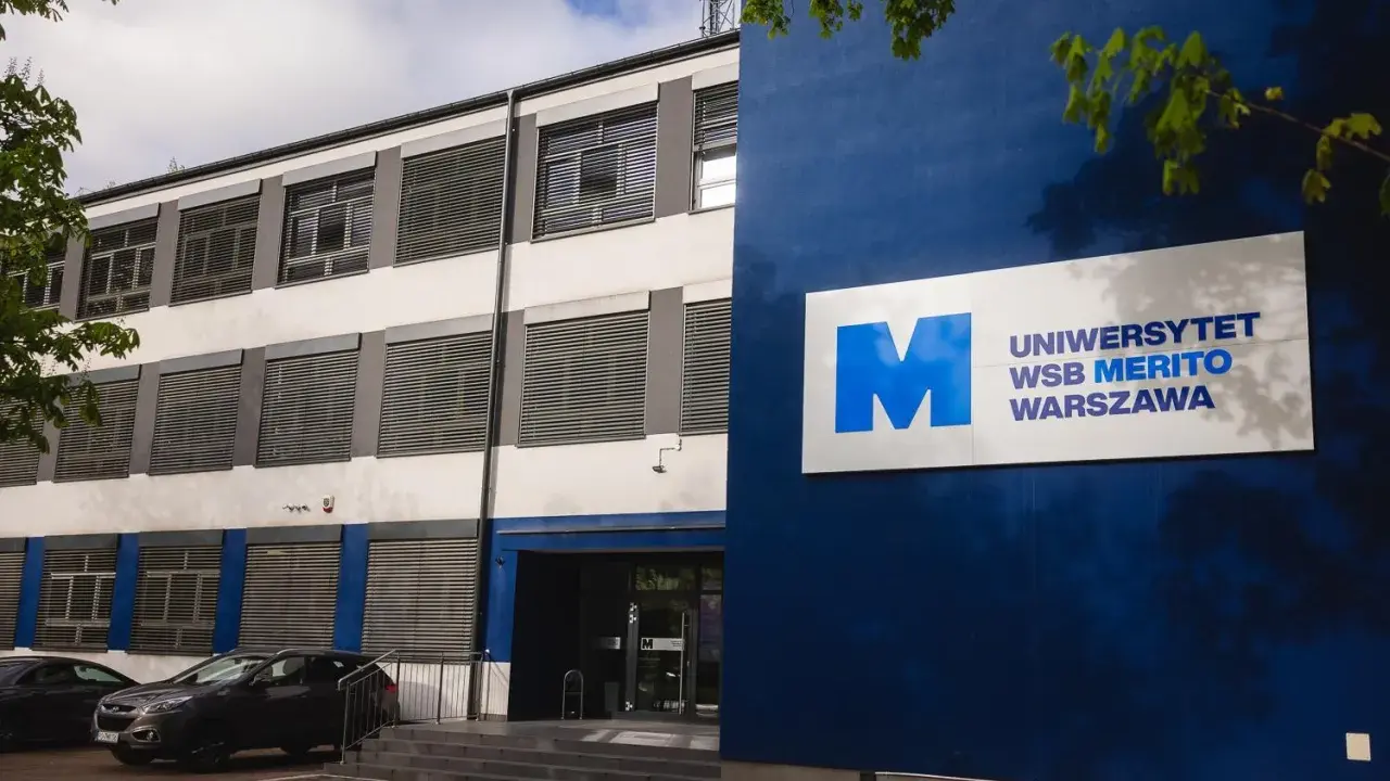 Nowoczesny budynek Uniwersytetu WSB Merito Warszawa z niebieskim logo.