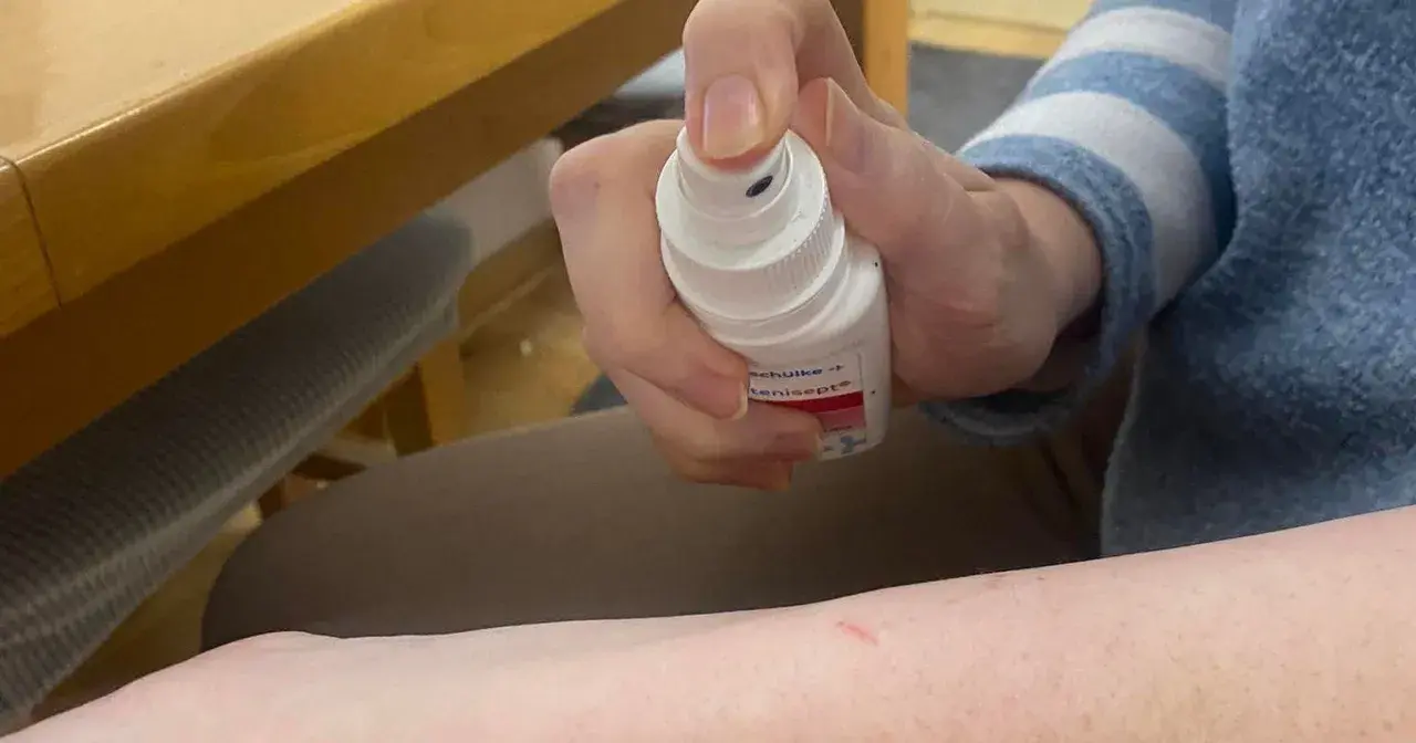 Dłoń trzymająca spray z oktenidyną, gotowa do dezynfekcji skóry.
