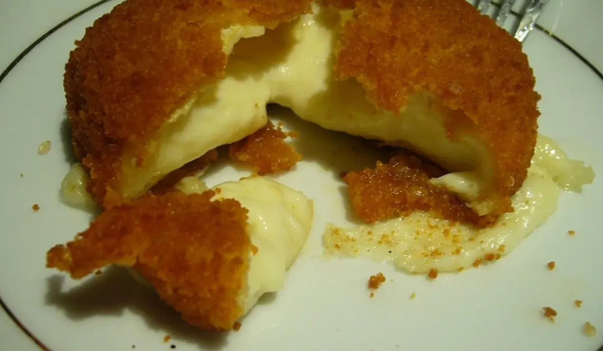 Pyszny camembert w panierce, z którego wypływa gorący, ciągnący się ser. Idealna przekąska na ciepło.