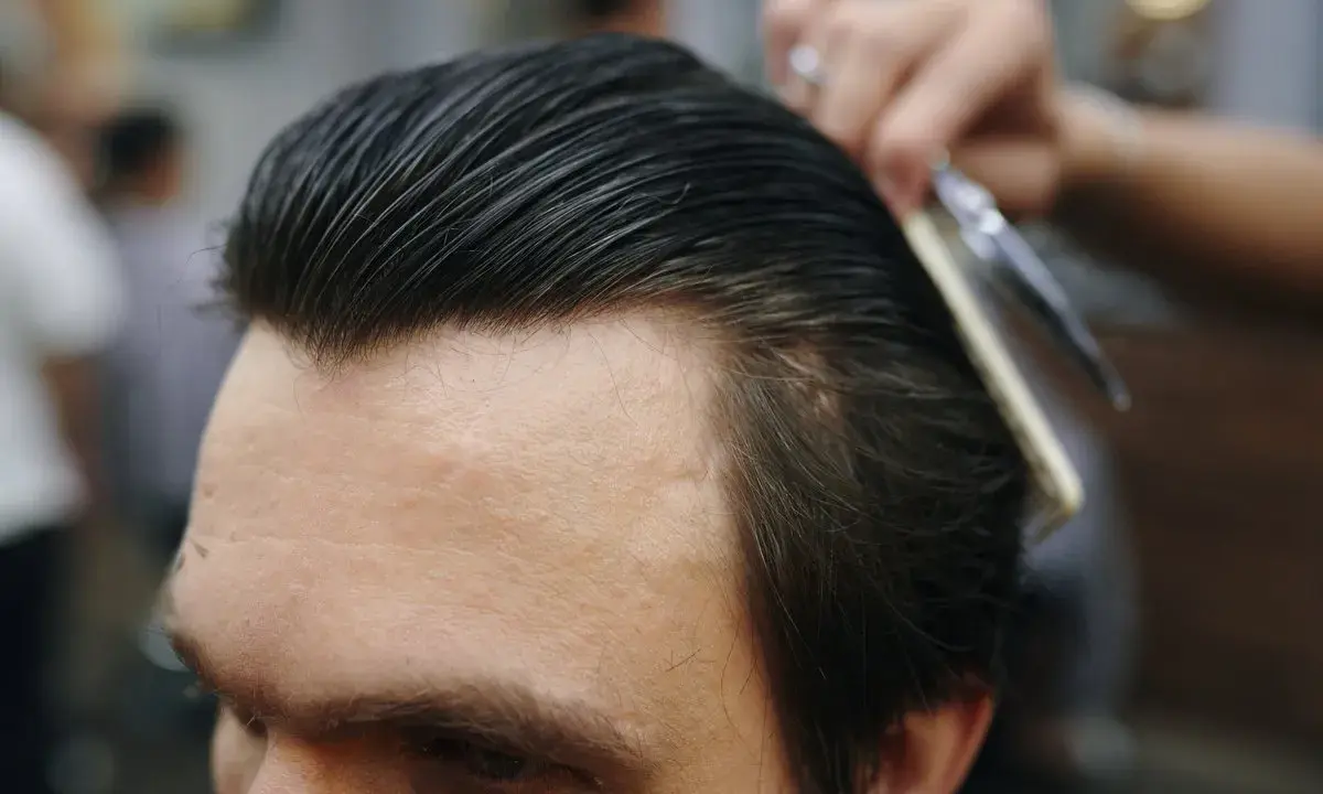 Profesjonalny styling włosów: grzebień i nożyczki w akcji, tworząc idealną fryzurę.