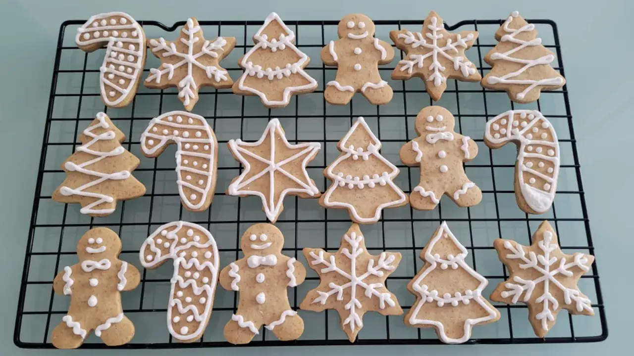 Galletas de jengibre decoradas con glaseado blanco: hombres, árboles, bastones de caramelo y copos de nieve.