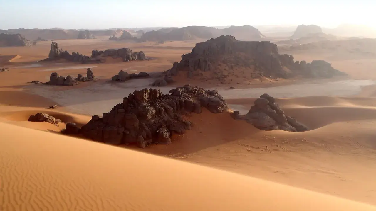 Sanddünen und Felsformationen in der algerischen Kulturlandschaft der Sahara. Ein Ort, der Geschichten von Nomaden und alten Zivilisationen erzählt.