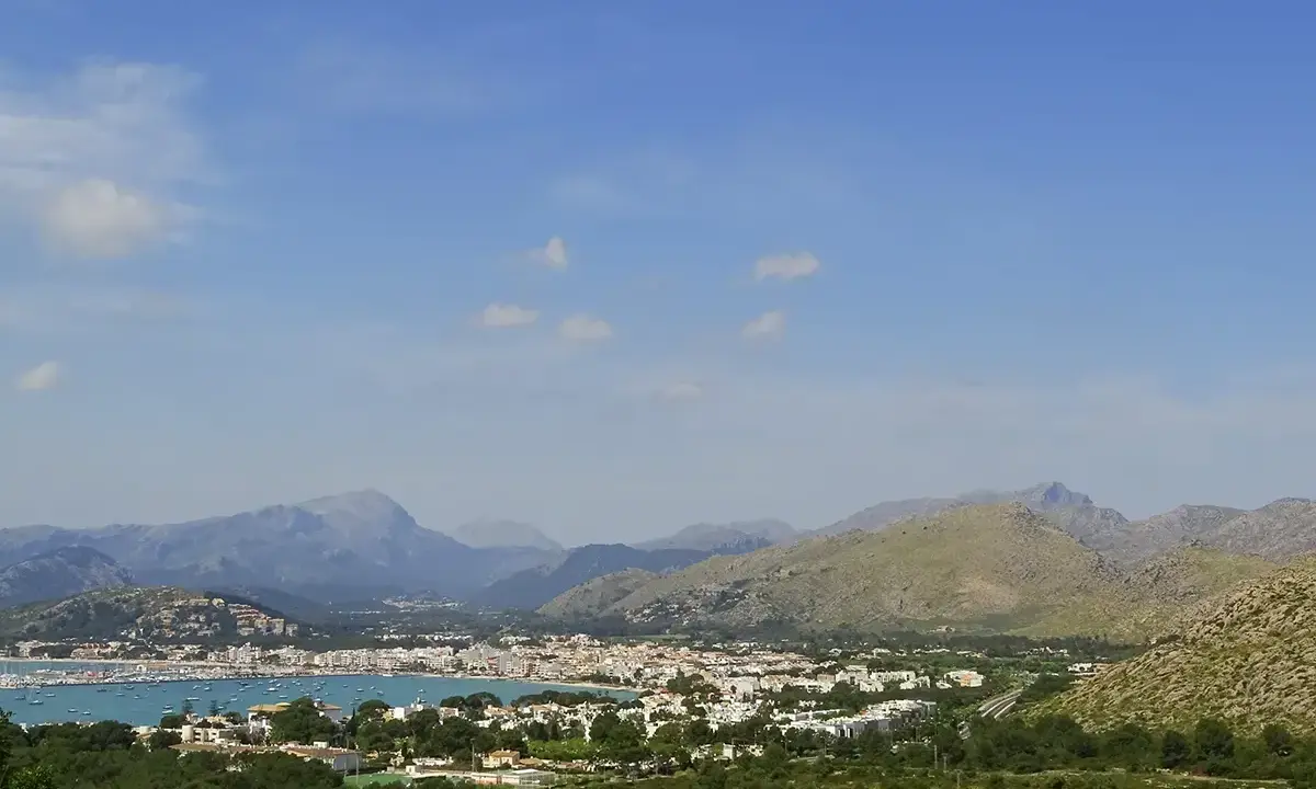 Vista panoramica del porto di Maiorca con montagne sullo sfondo e un mare pieno di barche.