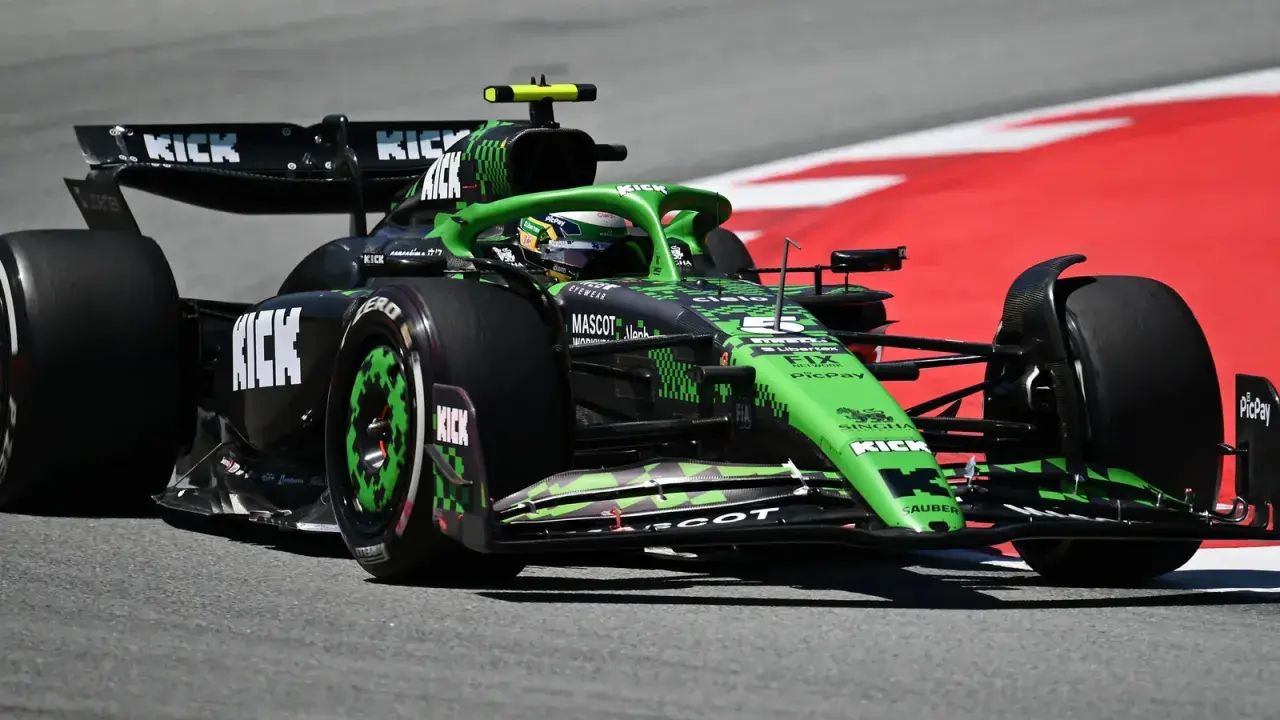 Ein grüner Formel 1 Bolide mit KICK-Sponsorenaufdruck rast auf der Rennstrecke. Die leistungsstarken Formel 1 Motoren lassen ihn über den Asphalt fliegen.