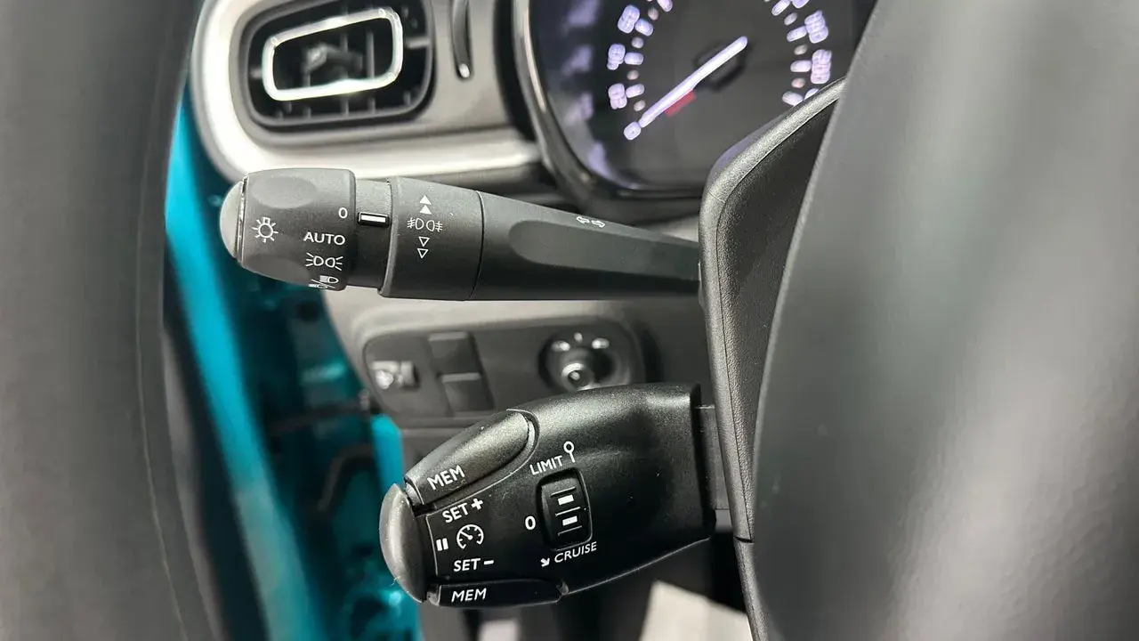 Palanca de luces con función AUTO y controles de crucero. Las luces adaptativas del coche se activan automáticamente.