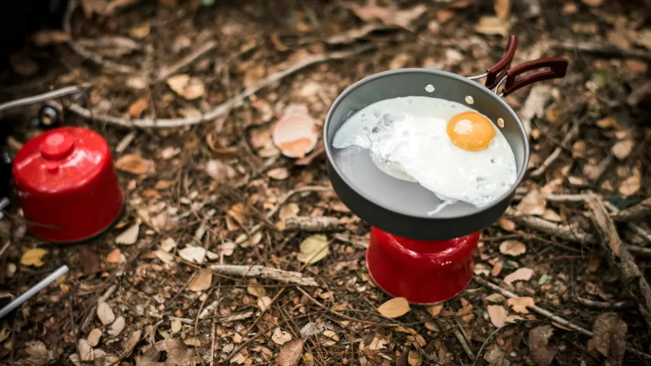 Stekt ägg i stekpanna på campingkök. Enkel och bra vandringsmat som ger energi för äventyret.