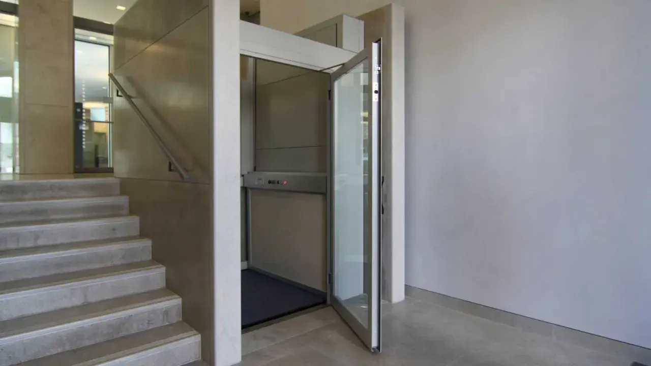 Una piattaforma elevatrice accanto a una scala, una soluzione per chi cerca come abbassare i gradini di una scala, rendendo l'accesso più agevole.