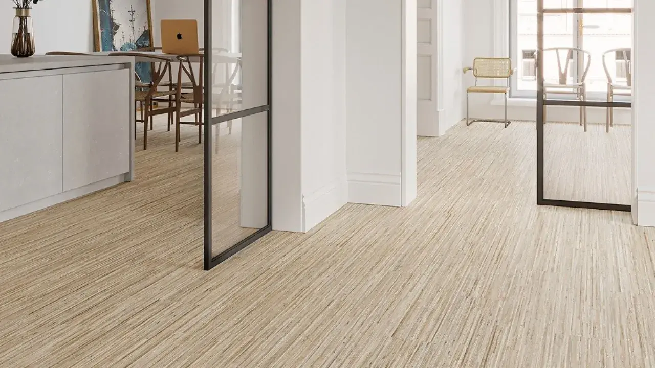 Un moderno revestimiento del suelo de madera clara con un diseño lineal crea un ambiente acogedor en un interior luminoso.