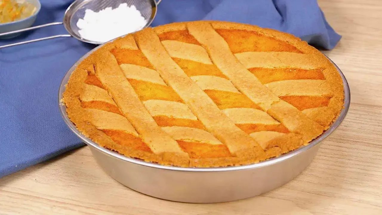 Pastiera napoletana ricetta originale: una torta dorata con decorazione a griglia, pronta per essere gustata.