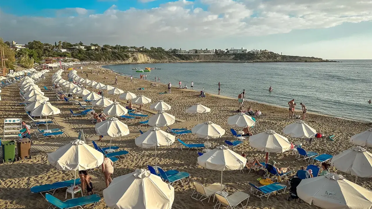 Piękna plaża na Cyprze, gdzie cypr pogoda w listopadzie pozwala na relaks pod białymi parasolami.