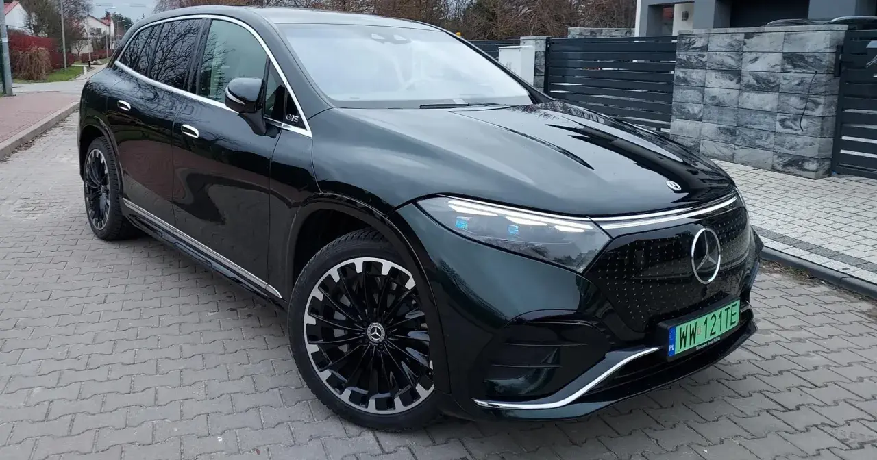 Elegancki, ciemnozielony Mercedes EQS SUV z nowoczesnymi światłami i felgami stoi na podjeździe.