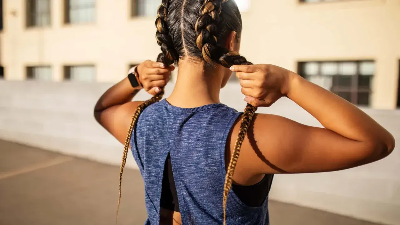 Frauen flechten Boxer Braids für ein sportliches Outfit.